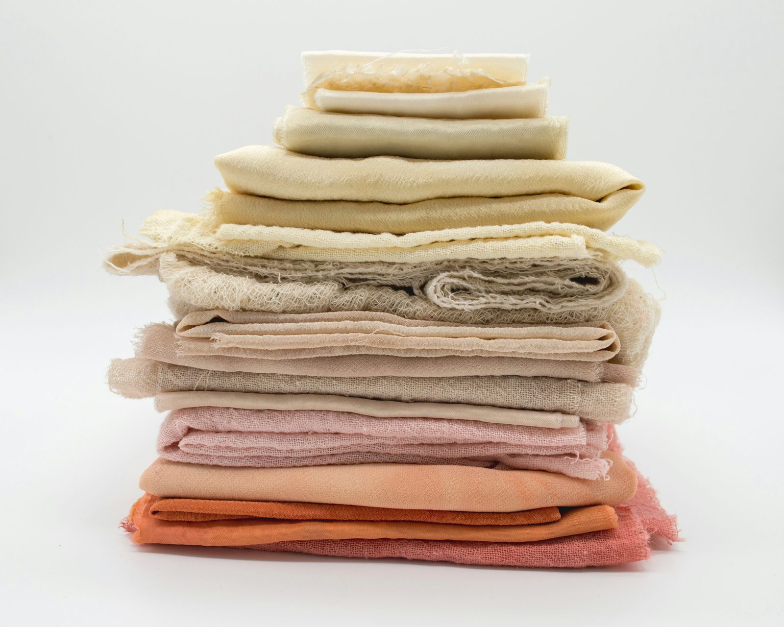 A neatly folded stack of fabric in warm, neutral tones