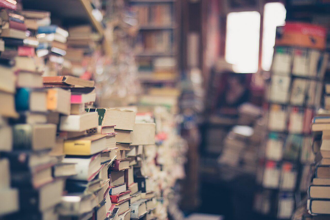 Stacks of old books on shelves in a bookshop